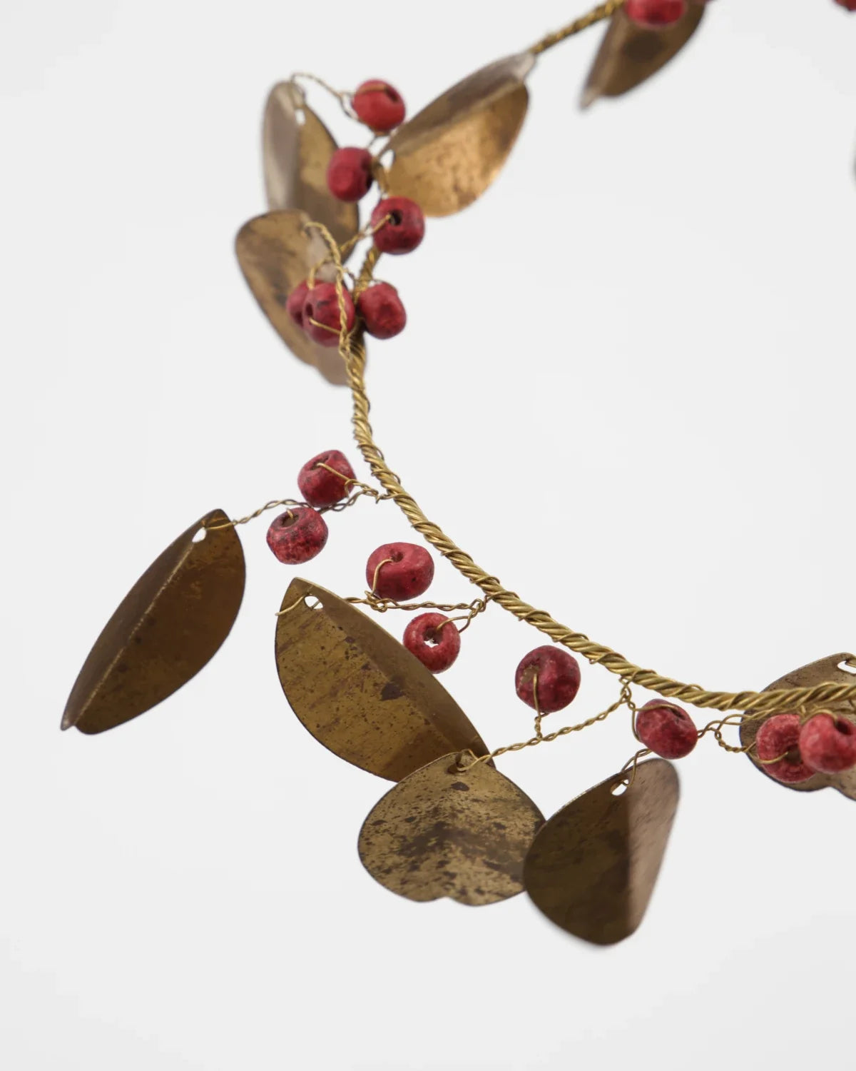 Weihnachtskranz mit goldenen Messingblättern und roten Holzperle